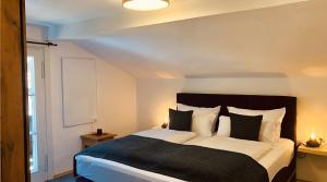 a bedroom with a large bed with black and white pillows at Ferienhaus Anni in Kreuth