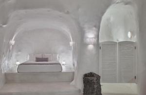 um quarto branco com uma cama num quarto arqueado em Villa Ioli Anastasia em Firostefani