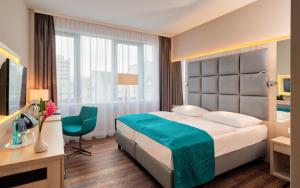 a hotel room with a large bed and a television at Hollywood Media Hotel am Kurfürstendamm in Berlin