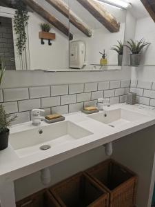 a white bathroom with two sinks and a mirror at Chambre des rêves, vue exceptionnelle sur terrasse privée,la Casamatta in Centuri