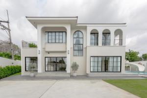a white house with black windows at Siwara poolvilla in Jomtien Beach