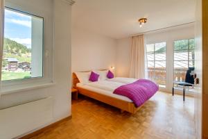 - une chambre avec un lit et une grande fenêtre dans l'établissement Bacchus Saas-Fee, à Saas-Fee