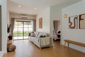 a living room with a couch and a window at Siwara poolvilla in Jomtien Beach