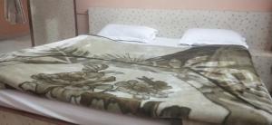 a bed with a blanket with flowers on it at Hotel Raj Guest House in Jaipur +77 photos