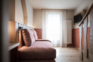 a living room with a chair and a window at Bella Posta Hotel in Soprabolzano