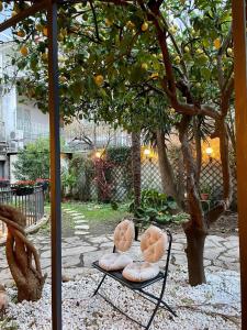 two stuffed animals sitting on a chair under an orange tree at Hotel Pace in Pompei