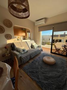 a bedroom with a bed and a living room at Casa das Oliveirinhas in Alvor