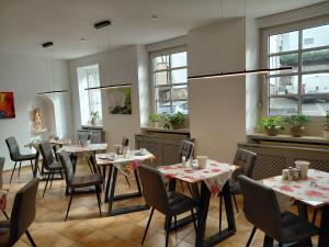 a dining room with tables and chairs and windows at Pension Elisabeth in Cochem