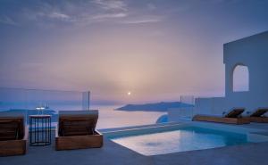 uma casa com uma piscina com vista para o oceano em Villa Ioli Anastasia em Firostefani