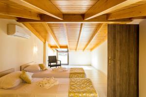 a bedroom with two beds and a wooden ceiling at Polyxenia Suites in Rethymno