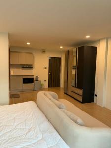 a large white bed in a room with a kitchen at The Sweet Escape in Ban Kathu (1)
