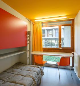 a room with a bed and a table and chairs at Centre International de Séjour André Wogenscky in Saint-Étienne