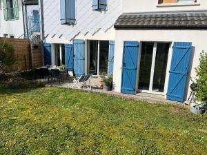 a house with blue doors and a yard at Appartement RDC quartier calme in Saint-Dizier