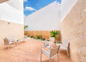 a patio with chairs and tables and a brick wall at Quintessenza- Luxury Suites in Leverano
