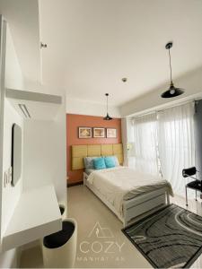 a bedroom with a bed and a tv in it at Studio Unit in Manhattan Heights with Balcony in Sampong +8 photos