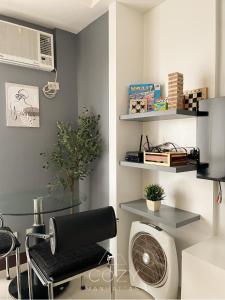 a room with a chair and a desk with a fan at Studio Unit in Manhattan Heights with Balcony in Sampong