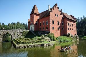 a group of people in a boat in front of a castle at Wellness Penzion Palice in Jindřichŭv Hradec