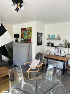 a living room with a desk and a table with chairs at Appartement RDC quartier calme in Saint-Dizier