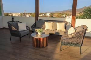 a living room with a couch and a table and chairs at Monbelt Luxury Apartment with Rooftop Jacuzzi in Puerto Vallarta