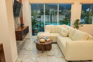 a living room with a white couch and a table at Monbelt Luxury Apartment with Rooftop Jacuzzi in Puerto Vallarta