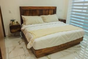 a bedroom with a large bed with a wooden headboard at Monbelt Luxury Apartment with Rooftop Jacuzzi in Puerto Vallarta