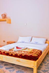 a bed with white sheets and pillows on it at Bwindi Breeze Lodge in Kisoro