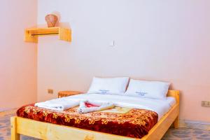 a bed with two towels on top of it at Bwindi Breeze Lodge in Kisoro +1 photo