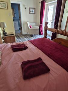 a bedroom with a large bed with two towels on it at Pinetree Cottage, dog friendly, Holiday let, Callander Invertrossachs in Callander