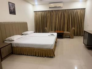 a hotel room with a bed and a television at Hotel Sitara Grand, KPHB in Hyderabad