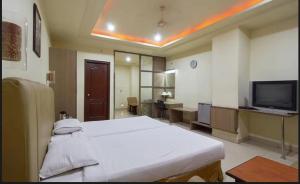 a hospital room with a bed and a tv at Hotel Sitara Grand, KPHB in Hyderabad