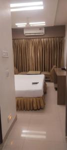 a bedroom with a bed in a room with curtains at Hotel Sitara Grand, KPHB in Hyderabad