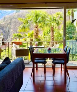 a dining room with a table and a large window at Casa Ruth Brissago in Brissago