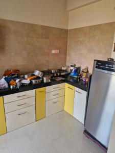 a kitchen with yellow and black counters and a refrigerator at Anwesha's Home Stay Alibaug in Alibaug