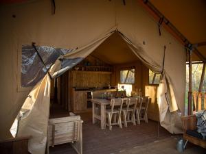 a tent with a table and chairs in a room at Village de Montmarsis in Gourdon