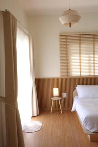 a bedroom with a bed and a window and a table at Yugen House - Yuma in Nong Prue