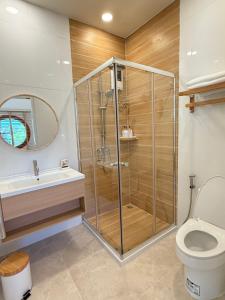 a bathroom with a shower and a toilet and a sink at Yugen House - Yuma in Nong Prue