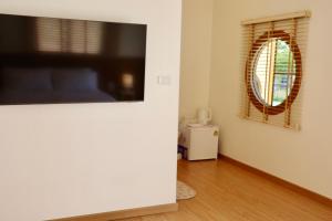 a living room with a flat screen tv on a wall at Yugen House - Yuma in Nong Prue +2 photos