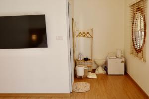 a bathroom with a toilet and a refrigerator at Yugen House - Yuma in Nong Prue