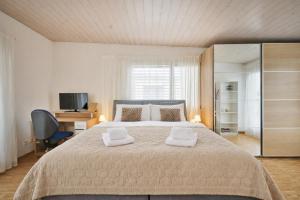 a bedroom with a large bed with two towels on it at Chalet in Thun, modern, spacious, perfect location in Thun