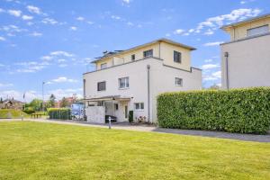 a white building with a grassy yard in front of it at Chalet in Thun, modern, spacious, perfect location in Thun
