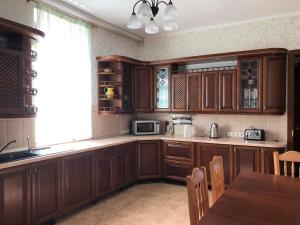 a kitchen with wooden cabinets and a table and a window at Ethno Complex Ukrayinske Selo in Buzovaya +86 photos