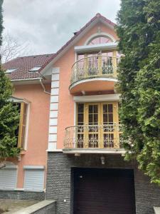 a pink house with a balcony on top of it at Ethno Complex Ukrayinske Selo in Buzovaya