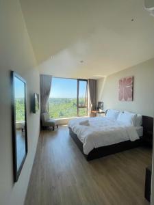 a bedroom with a large bed and a large window at Le VyN Mang Den in Kon Plong