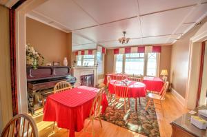 a dining room with red tables and chairs at The Sonata Inn in Charlottetown