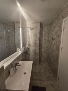 a bathroom with a sink and a shower at Budva Central Escape Apartment in Budva +8 photos