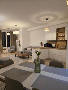 a kitchen and living room with a table and chairs at Budva Central Escape Apartment in Budva