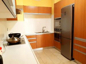 a kitchen with a stainless steel refrigerator and a sink at Sea & City View Luxury Apartment in Port Louis