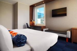 a hotel room with a bed and a window at Aloft by Marriott Stuttgart in Stuttgart +39 photos