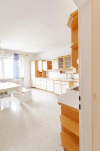 a kitchen with white cabinets and a white table at Vacation, Work, Party in Allerstorf
