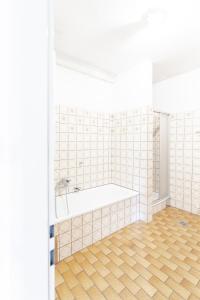 a bathroom with a tub and a wooden floor at Vacation, Work, Party in Allerstorf
